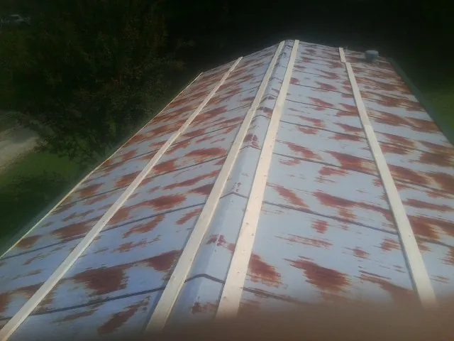 Rusted metal roof panels with new wood purlins before replacement — Storm Damage Roof Repair in Waterloo by Roofing Brothers